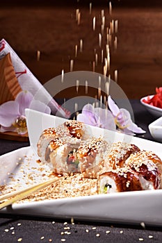 Sushi set compositionally located on a dark surface.