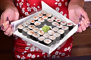 Sushi set compositionally located on a dark surface.