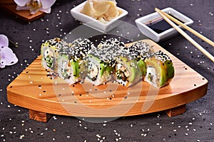 Sushi set compositionally located on a dark surface.