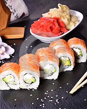 Sushi set compositionally located on a dark surface.