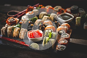 Sushi set food photo. Rolls served on brown wooden and slate plate. Close up of sushi. Modern toning image