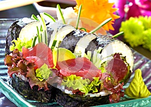Sushi set with maki , futomaki. Sushi with salmon, tuna, raw fish, on a blue, glass plate.