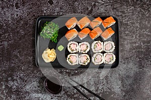 Sushi set of maki rolls with wakame salad served on stone plate. Traditional japanese food