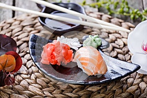 Sushi Set nigiri and sushi rolls decorated with flowers on bamboo background. Japanese cuisine.