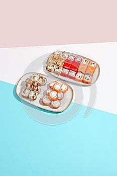 Sushi set: Philadelphia, california, canada maki rolls on ceramic plate. Trendy set of maki sushi in minimal style. Modern