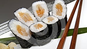 Sushi set. Salmon maki rolls and wooden chopsticks. Japanese delicacy.
