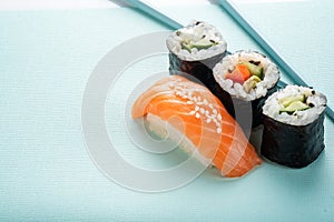 Sushi set with salmon nigiri and roll with cucumber and vegetables with chopsticks