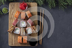 Sushi set of salmon, tuna and eel as Christmas tree served on a wooden board as Xmas decoration on a dark background