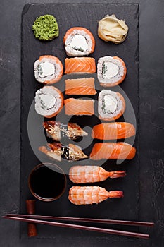 Sushi Set sashimi with salmon, shrimp, eel and sushi rolls philadelphia served on stone slate. Top view