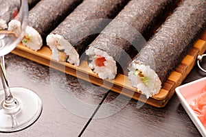 sushi on the wooden table. Empty glass for wine