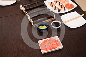 sushi set with sauce and wooden sticks on the brown table