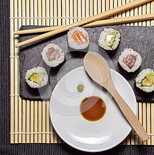 Sushi slate table with chopsticks and hot sauce and soy sauce on bamboo rubber photo