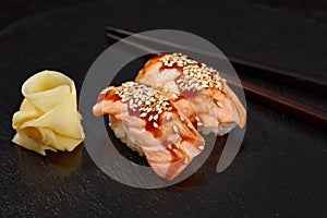 Sushi with smoked eel and sesame seeds on a black background. Japanese dish Unagi sushi.