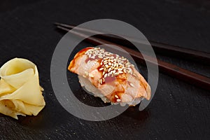 Sushi with smoked eel and sesame seeds on a black background. Japanese dish Unagi sushi.