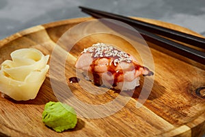 Sushi with smoked eel and sesame seeds on a black background. Japanese dish Unagi sushi.