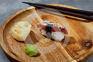 Sushi with smoked eel and sesame seeds on a black background. Japanese dish Unagi sushi.