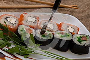Sushi strung with a fork, Japanese rolls, fish and rice,