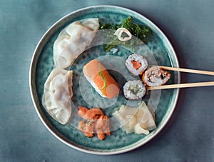 Sushi and sushi roll set on blue plate top view