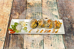 Sushi uramaki tempura futomaki with sauce, paprika and avocado