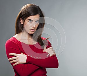 Suspecting 30s woman standing with arms crossed