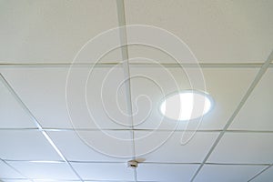 Suspended ceiling made of square plasterboard slabs with built-in round LED lighting. Close-up details of the ceiling in the