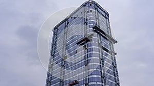 Suspended construction craddle near glass wall of hightower residentaial building