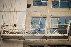 The suspended cradle for exterior work in hi-rise building construction. The gondola lift or stage scaffolding for external repai