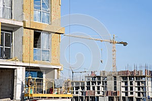 Suspended cradle/mobile scaffolding platform for construction work at height. Mineral wool for insulation of the facade building.