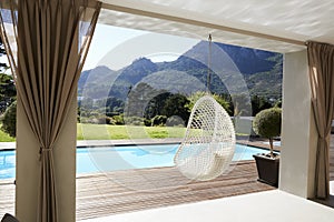 Suspended Seat Next To Decking Around Outdoor Swimming Pool photo