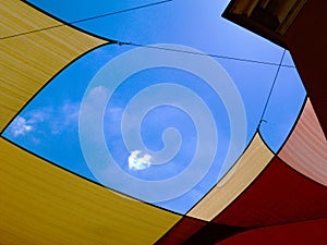 Suspended sun protection awning or tent of cotton fabric stretched over street in old European town