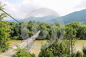 Suspended wooden bridge across Schodnica river