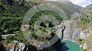 Suspension Bridge and canyon with two kayak steaming down the river. Famous Commercial Bungee Jumping spot, called Kawarau Bridge