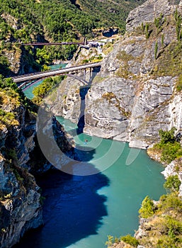 Suspension Bridge and canyon with two kayak steaming down the river. Famous Commercial Bungee Jumping spot, called Kawarau Bridge