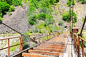 Suspension bridge. Old rusty road bridge over a mountain river in Georgia