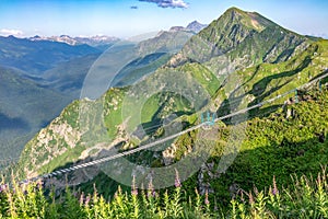 Suspension bridge over an abyss in the mountains near the ski resort Rosa Khutor in Krasnaya Polyana. Sochi, Russia.