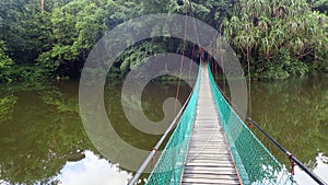 The suspension bridge over the lake at Rainforest Discovery Centre In Sepilok, Borneo