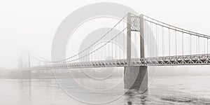 Suspension bridge over the Loire disappears on a foggy day, Ancenis, France