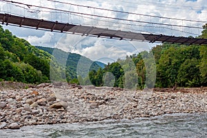 Suspension bridge over the mountain river