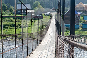 Suspension bridge over a stormy mountain river