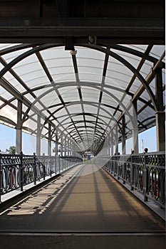 Suspension bridge with a roof in the form of an arch on a summer day.