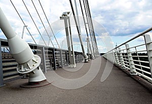 Suspension bridge sidewalk detail. haavy white steel cables and railing