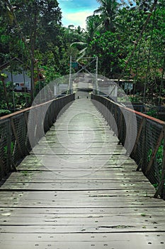 a suspension bridge that spans for local residents access with steel and wood construction,
