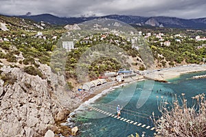 Suspension bridge to the Diva rock, Black Sea coast, near Yalta, Crimea. Panorama of the town of Simeiz