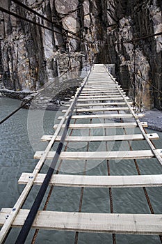 Suspension Hussaini bridge in Passu, Upper Hunza. Karakoram mountains and Hunza river