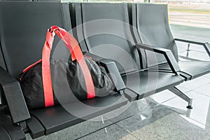 Suspicious black sport bag left on chairs unattended. Lost luggage. Concept of safety in public places and terrorism