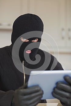 Suspicious burgler holding tablet pc photo