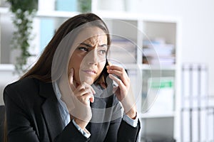 Suspicious executive calling on smart phone at office photo