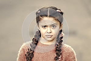 Suspicious look. Kanekalon strand in braids of child. Braided hairstyle concept. Girl with braided hair style pink