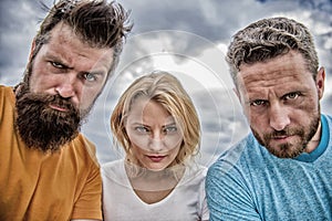 Suspicious look. Threesome suspiciously look down. Woman and men look confident sky background. Strength in unity. Stand