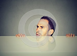 Suspicious man peeking from under table